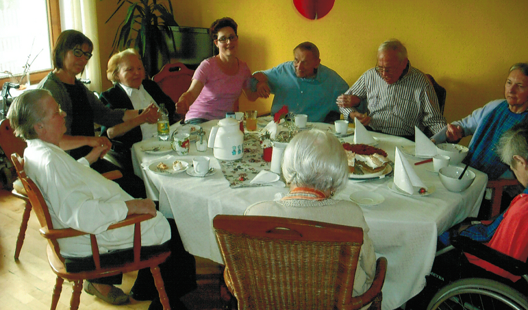 Senioren und Betreuer essen Kuchen